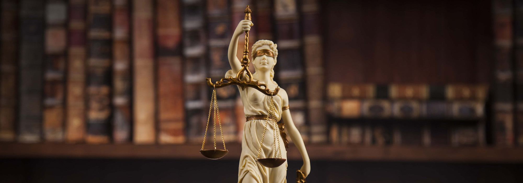 Antique statue of justice law books background