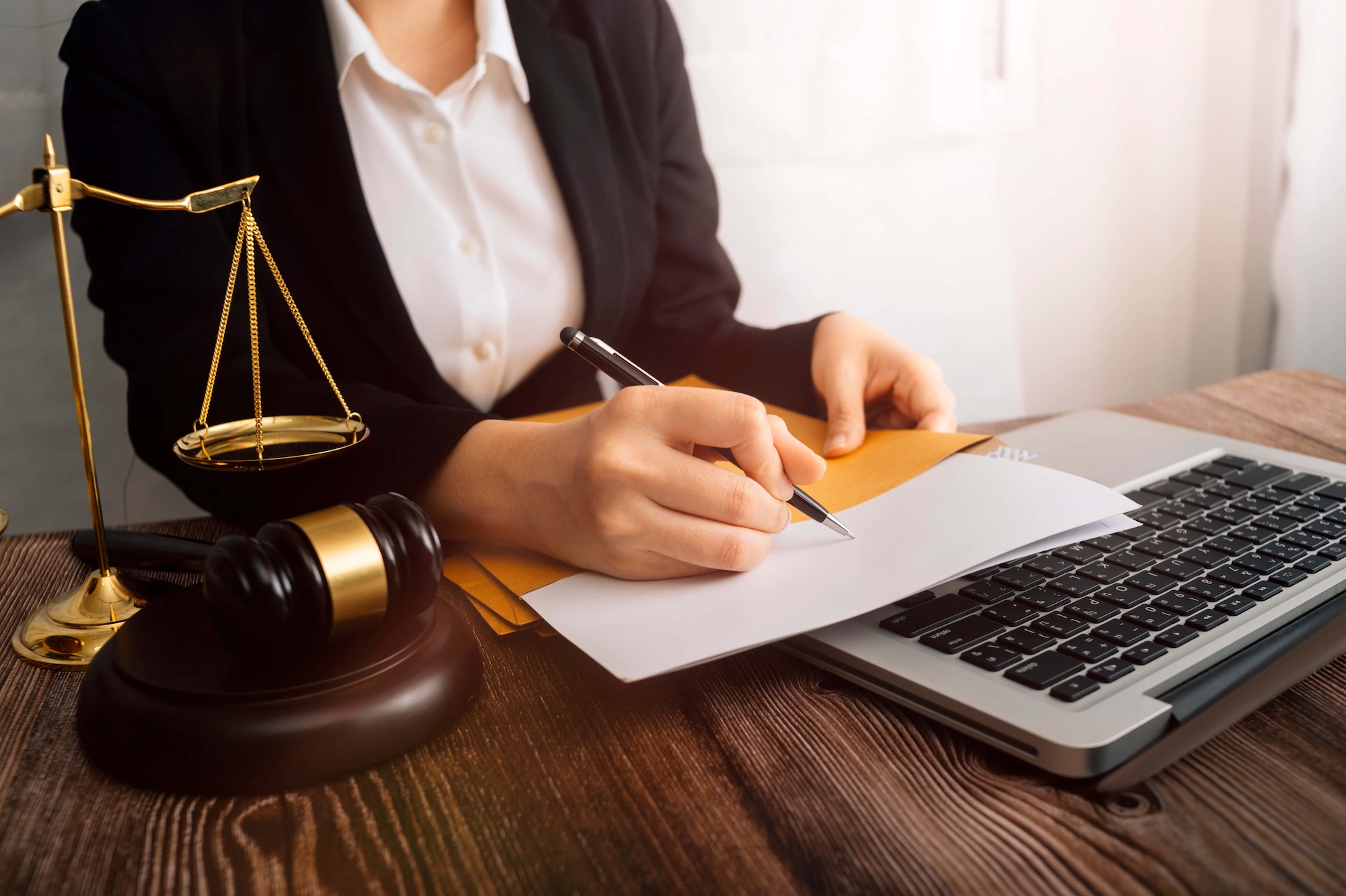 Business and lawyers discussing contract papers with brass scale on desk in office. Law legal services advice justice and law concept