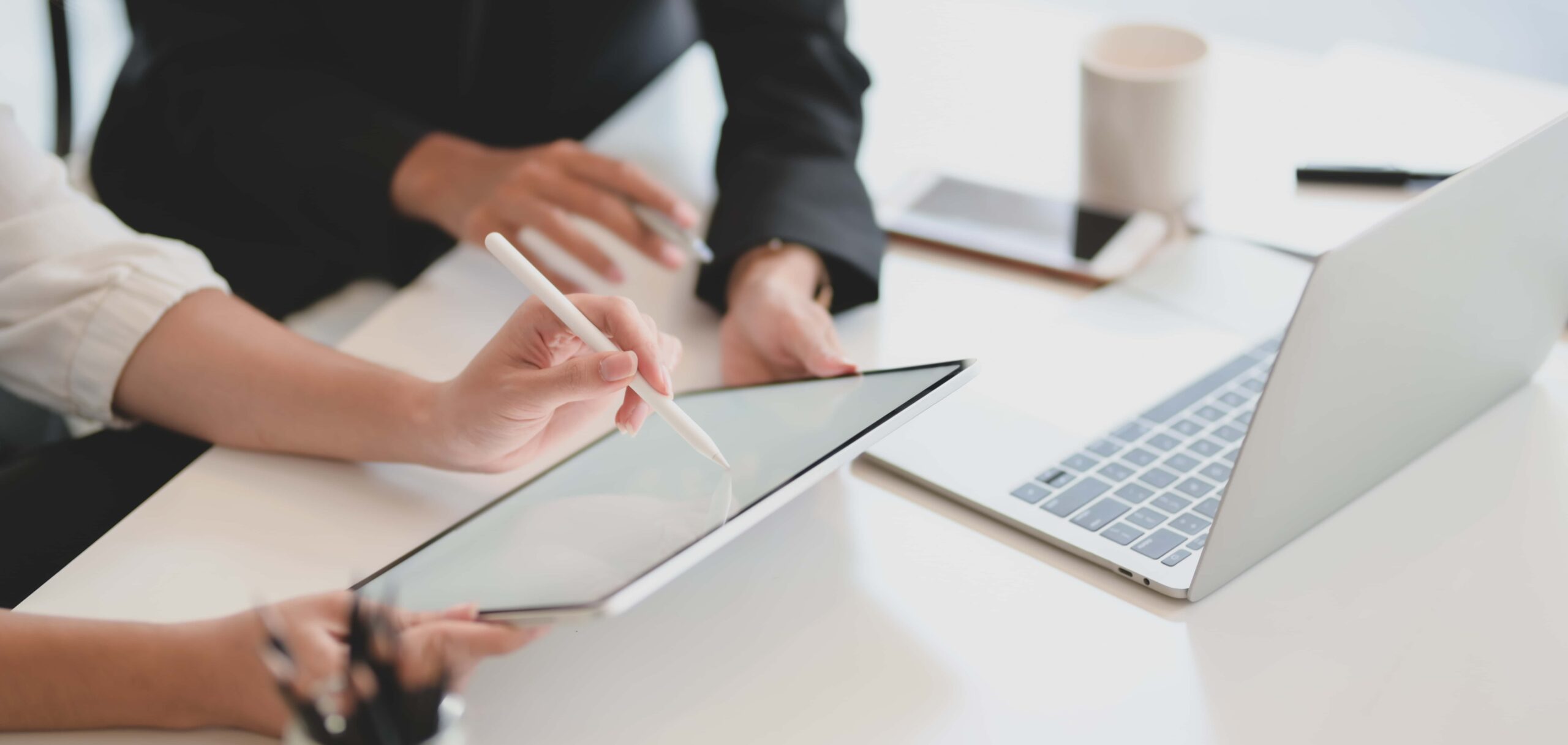 Cropped shot of young businesswoman explaining her idea to her coworker with blank screen tablet  scaled