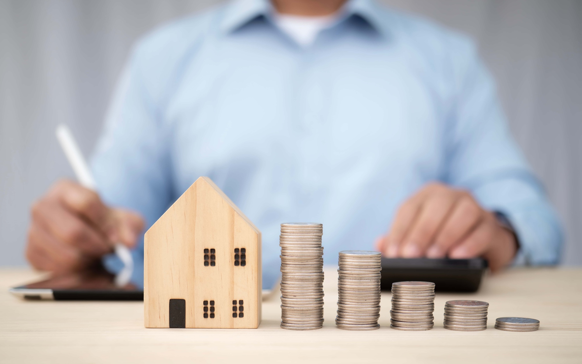 businessman work with tablet and using calculator to calculate with coin stack.saving plan to buy house personal financial concept for own a house