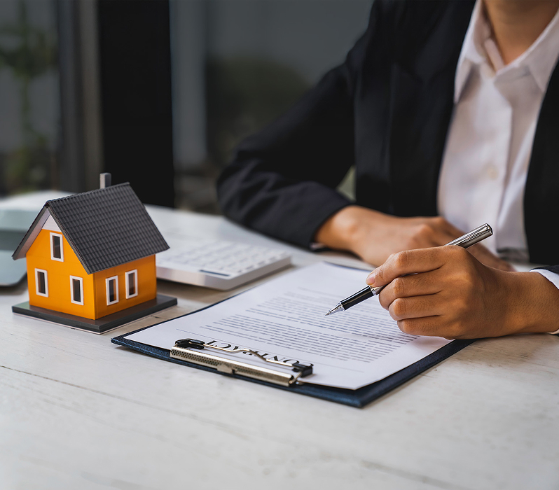 attorney reviews document next to house model
