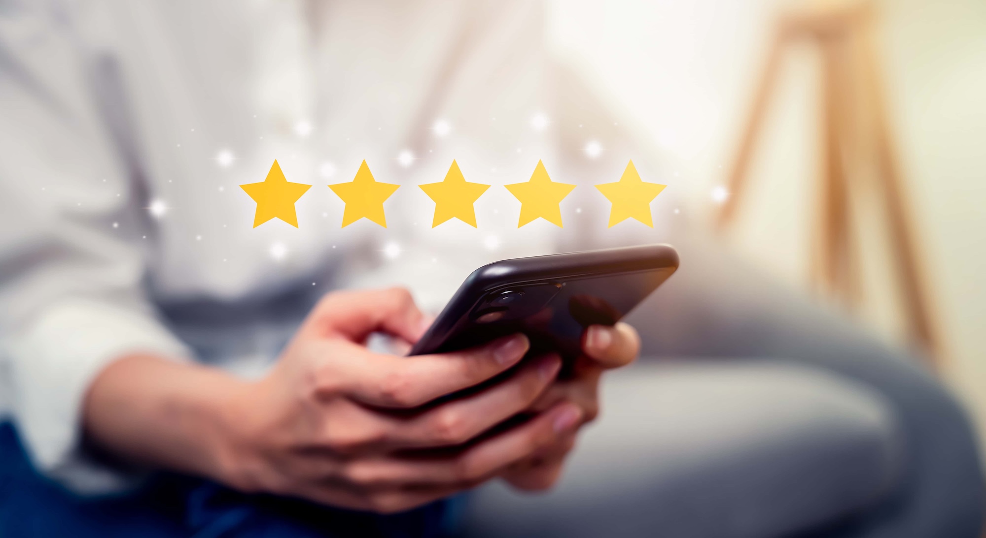 person typing on their phone with stars above it