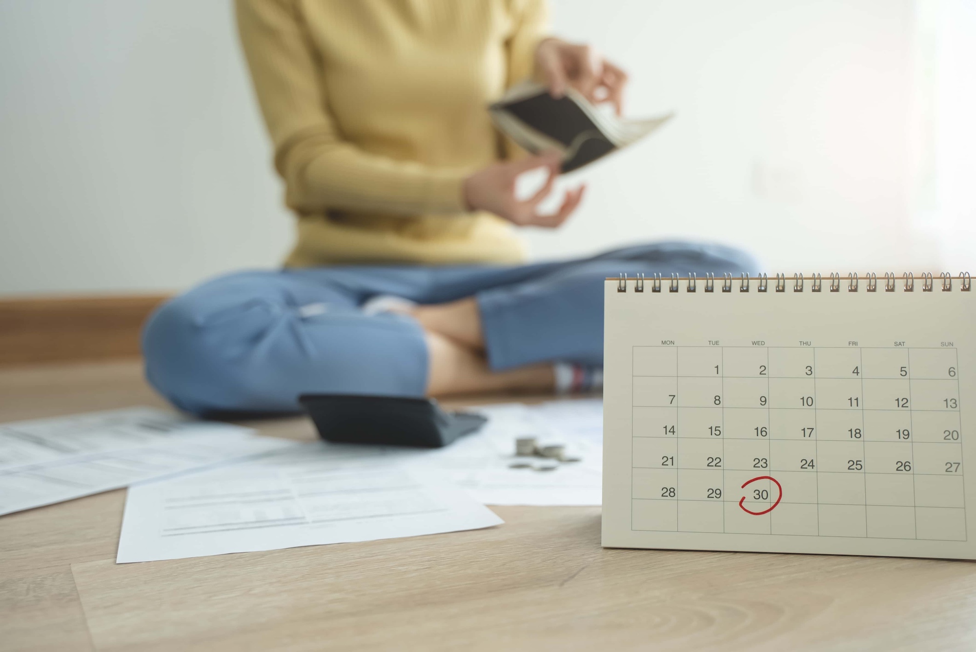 the stressed person sitting on the floor opening empty wallet