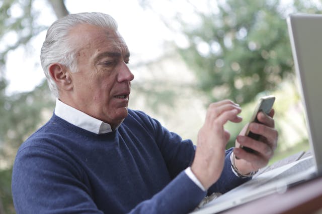elderly man looking at his phone